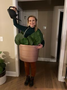 a woman holding a potted plant in her hands