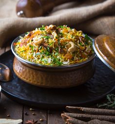 a bowl filled with food sitting on top of a table next to spices and utensils