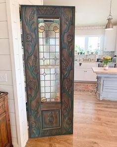 an old door with stained glass on the front and side panels is open in a kitchen