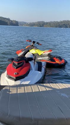 two jet skis are parked on the water