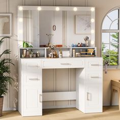 a white vanity with lights on it in front of a window and potted plant