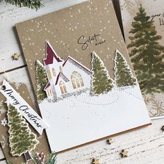 two christmas cards with trees and snow on them, one has a church in the background