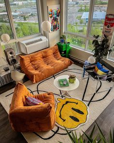 a living room with two couches and a rug in front of large windows overlooking the city