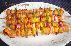 chicken and vegetable skewers on a white plate