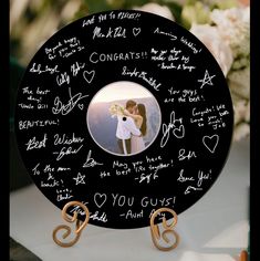 a black plate with writing on it that has a picture of two people holding each other