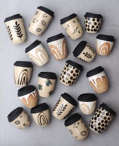 twelve coffee cups with designs on them are lined up in a row and placed next to each other