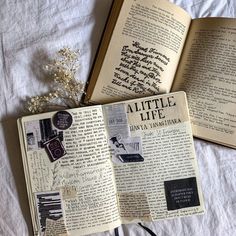 an open book sitting on top of a bed next to a string and flower bouquet