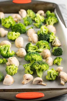 broccoli and mushrooms on a baking sheet ready to go into the oven in the oven