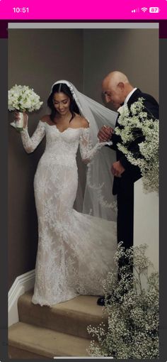 the bride is walking down the stairs with her father