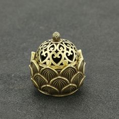 an ornate gold ring sits on a black surface