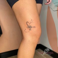 a woman's leg with a tattoo on it that has a scorpion on it