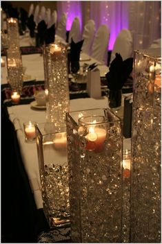 some candles are sitting in vases on a table