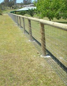 the fence is made of wire and has two posts on each side that are separated by a wooden post