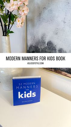 the modern manner for kids book sits on a desk next to a vase with flowers