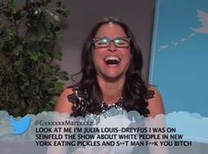 a woman with glasses is laughing while talking to someone on the screen in front of her