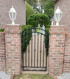 an iron gate in front of a brick house