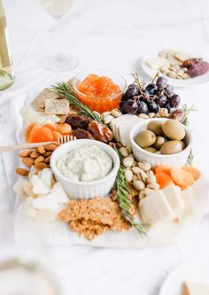 a platter filled with different types of food on top of a white table cloth