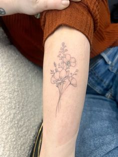 a woman with a tattoo on her arm holding a flower in one hand and a knife in the other