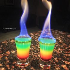 two blue and yellow vases with liquid pouring out of them on a granite countertop