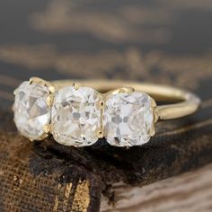 three stone diamond ring sitting on top of a book