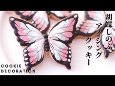 cookies decorated with pink and white butterflies are on a plate in front of the words cookie decoration