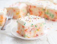 a slice of cake with sprinkles on a plate next to a fork