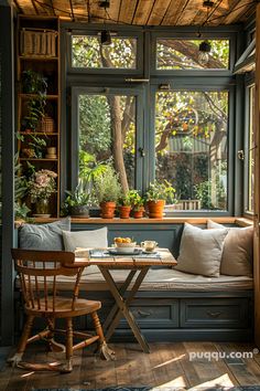 a table and chairs in front of a window with potted plants on the windowsill