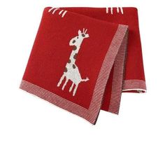 two red and white towels with giraffes on them, one is folded up