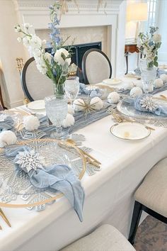 a dining room table set with blue and white decorations, plates and napkins on it