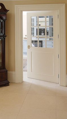 a grandfather clock sitting in the corner of a room next to a doorway with an open door