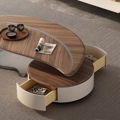 an oval coffee table with drawers on the bottom and one drawer open to reveal a magazine