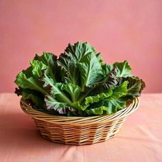 a basket filled with lettuce sitting on top of a pink cloth covered table