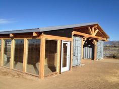 a small building that is made out of wood and metal with glass doors on the outside