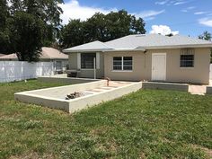 a house that is in the middle of a yard with grass and trees around it