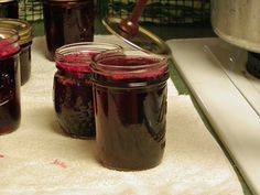 jars filled with red liquid sitting on top of a counter