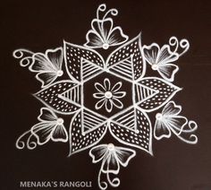 a white snowflake on a black background with the words menka's rangoli written below it