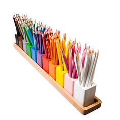 an assortment of colored pencils are in a holder