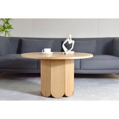 a living room with a couch, table and coffee cup on the floor in front of it