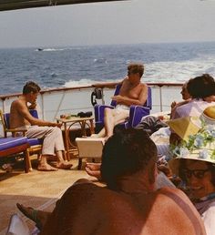 some people are sitting on the deck of a boat and one is wearing a sunhat