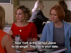 two women sitting at a table talking to each other with the caption new york is the perfect place to be single