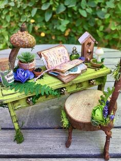 a green table topped with lots of plants next to a birdhouse and tree stump