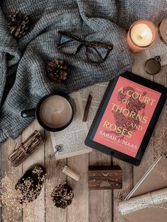 a book sitting on top of a wooden table next to some candles and other items