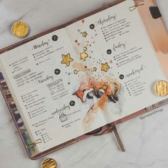 an open planner with gold coins on it