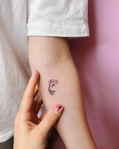 a woman's arm with a small tattoo on the left side of her arm