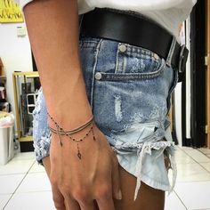 a woman wearing a black belt is holding her hand up to her waist and has a tattoo on it