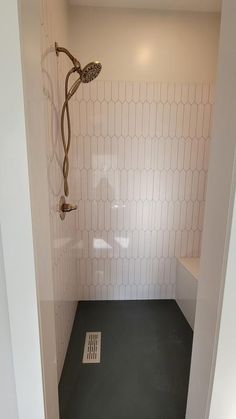 a bathroom with a shower head and tiled walls