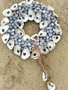 a wreath made out of seashells on the beach