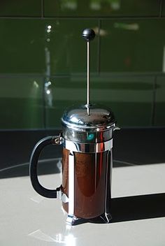 a french press coffee maker sitting on top of a table