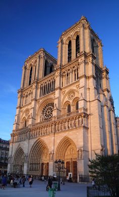 the large cathedral has many windows on it's sides and is surrounded by people