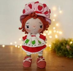 a crocheted doll is standing on a table